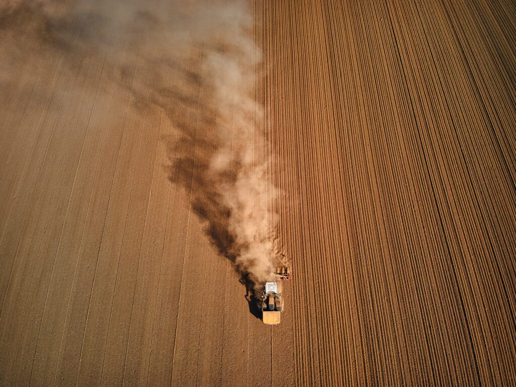 A tractor in a large field. Farming practices have contributed to the destruction of important insect habitats over the past century.